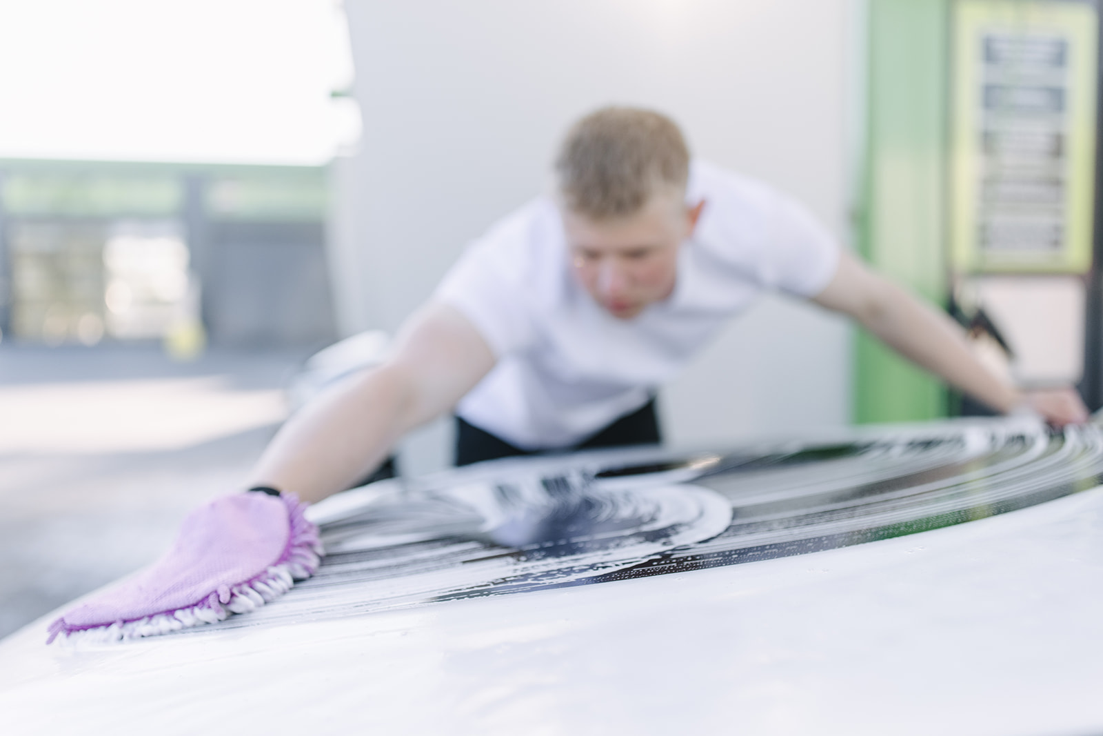 Autopfleger w&auml;scht Fahrzeugdach mit Waschhandschuh und Schaum &ndash; professionelle Handw&auml;sche bei Max UP