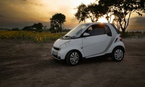 Wei&szlig;es Auto vor Sonnenblumenfeld bei Sonnenuntergang &ndash; stimmungsvolle Fahrzeugaufnahme in l&auml;ndlicher Umgebung